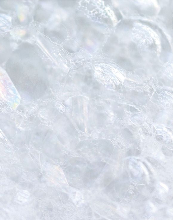 Close-up of bubbles and lather from Skin So Soft Soft & Sensual Bar Soap, highlighting its creamy texture.