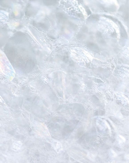 Close-up of bubbles and lather from Skin So Soft Soft & Sensual Bar Soap, highlighting its creamy texture.